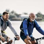 Junger und älterer Mann lachend beim Fahrradfahren